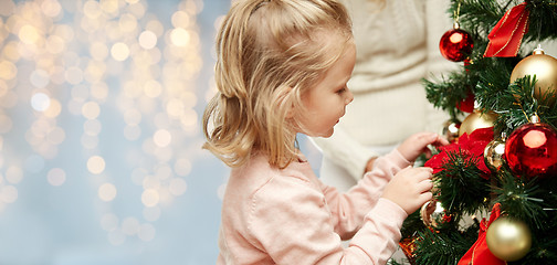 Image showing close up of little girl decorating christmas tree