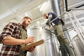 Image showing men with clipboard at brewery or beer plant kettle