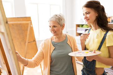 Image showing women with easels and palettes at art school