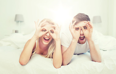 Image showing happy couple lying in bed at home