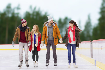 Image showing friends holding hands on outdoor skating rink