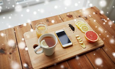 Image showing smartphone with cup of lemon tea, honey and ginger
