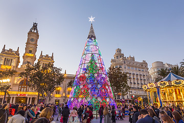 Image showing Christmas fair with colorful christmas tree and carousel on Modernisme Plaza of the City Hall of Valencia, Spain.