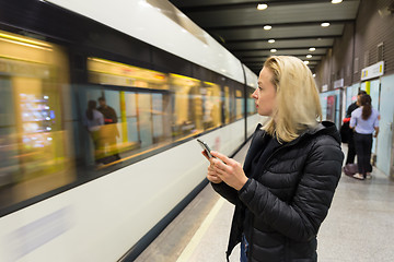 Image showing Woman with a cell phone waiting for metro.