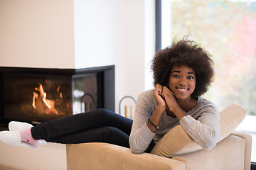 Image showing black woman in front of fireplace