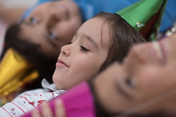 Image showing kids  blowing confetti while lying on the floor