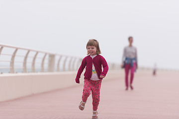 Image showing mother and cute little girl on the promenade by the sea