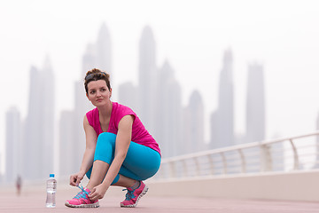 Image showing woman tying shoelaces on sneakers