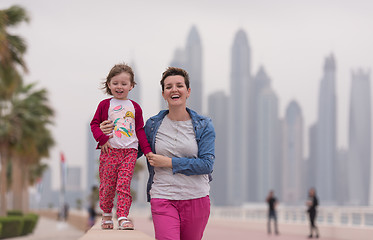 Image showing mother and cute little girl on the promenade