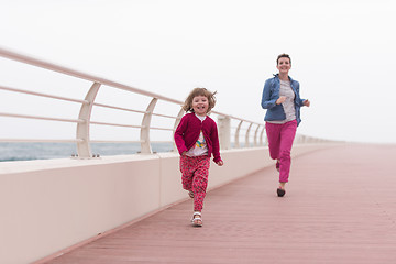 Image showing mother and cute little girl on the promenade by the sea