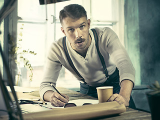 Image showing Architect working on drawing table in office