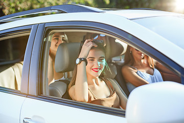 Image showing The young women in the car smiling