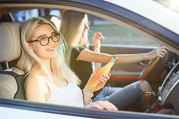 Image showing The young women in the car smiling