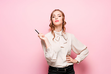 Image showing The serious frustrated young beautiful business woman on pink background