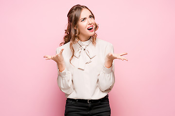 Image showing The serious frustrated young beautiful business woman on pink background