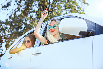 Image showing The young women in the car smiling