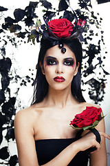 Image showing pretty brunette woman with rose jewelry, black and red, bright m