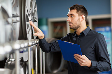 Image showing auto business owner and wheel rims at car service