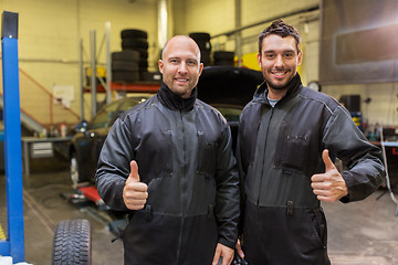 Image showing auto mechanics or tire changers at car shop