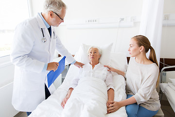 Image showing senior woman and doctor with clipboard at hospital