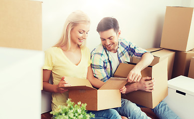 Image showing smiling couple with many boxes moving to new home