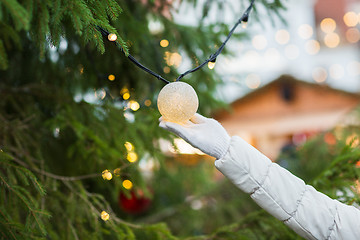 Image showing close up of hand with christmas tree garland bulb