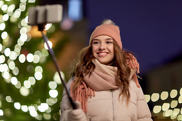 Image showing young woman taking selfie over christmas tree