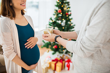 Image showing husband giving christmas present to pregnant wife