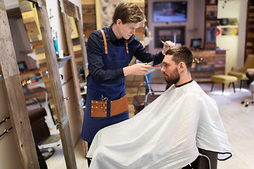 Image showing man and barber with trimmer cutting hair at salon