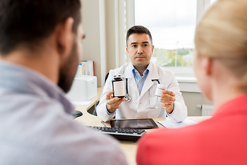 Image showing doctor showing medicine to family couple at clinic