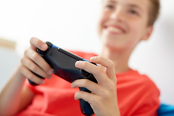 Image showing close up of boy with gamepad playing video game