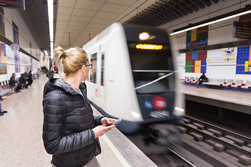 Image showing Woman with a cell phone waiting for metro.