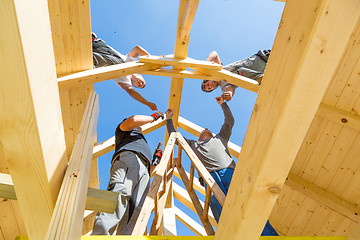 Image showing Builders at work with wooden roof construction.