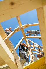 Image showing Builders at work with wooden roof construction.