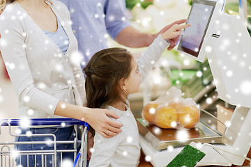 Image showing family weighing oranges on scale at grocery store