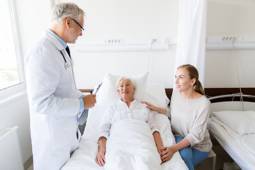 Image showing senior woman and doctor with clipboard at hospital