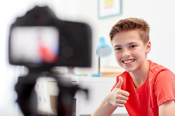 Image showing happy boy with camera recording video at home