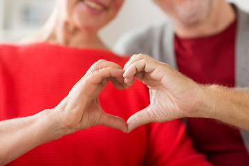 Image showing close up of senior couple showing hand heart sign