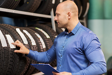 Image showing auto business owner and wheel tires at car service