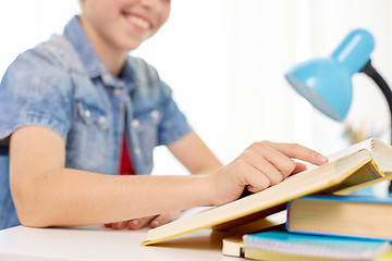 Image showing student boy reading book at home table