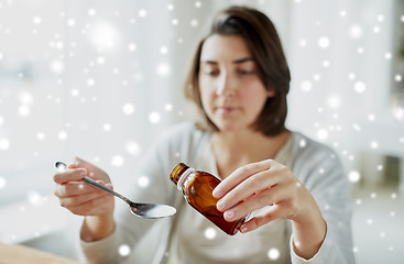 Image showing ill woman pouring medication from bottle to spoon