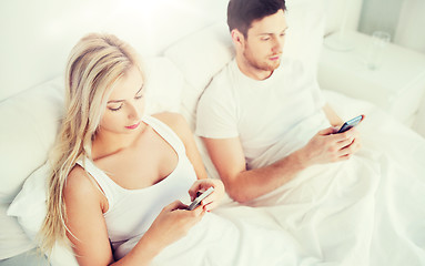 Image showing couple with smartphones in bed