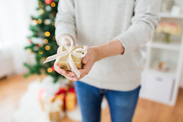 Image showing close up of man with christmas gift at home