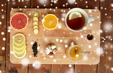 Image showing ginger tea with honey, citrus and garlic on wood