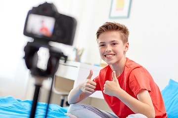 Image showing happy boy with camera recording video at home