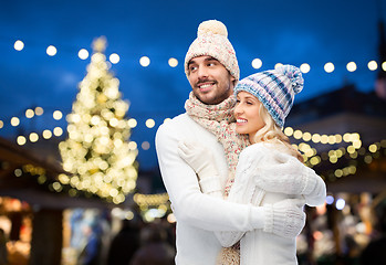 Image showing happy couple hugging over christmas tree lights