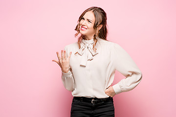 Image showing The serious frustrated young beautiful business woman on pink background