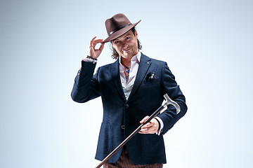 Image showing The mature man in a suit and hat holding cane.