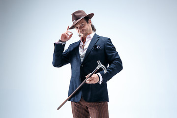 Image showing The mature man in a suit and hat holding cane.