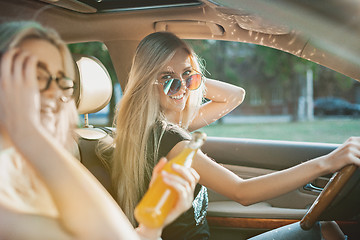 Image showing The young women in the car smiling